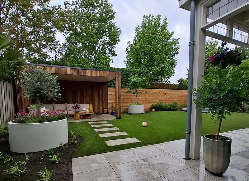 moderne-tuin-kunstgras-luxery Moderne achtertuin met kunstgras, staptegels, borders en houten overkapping
