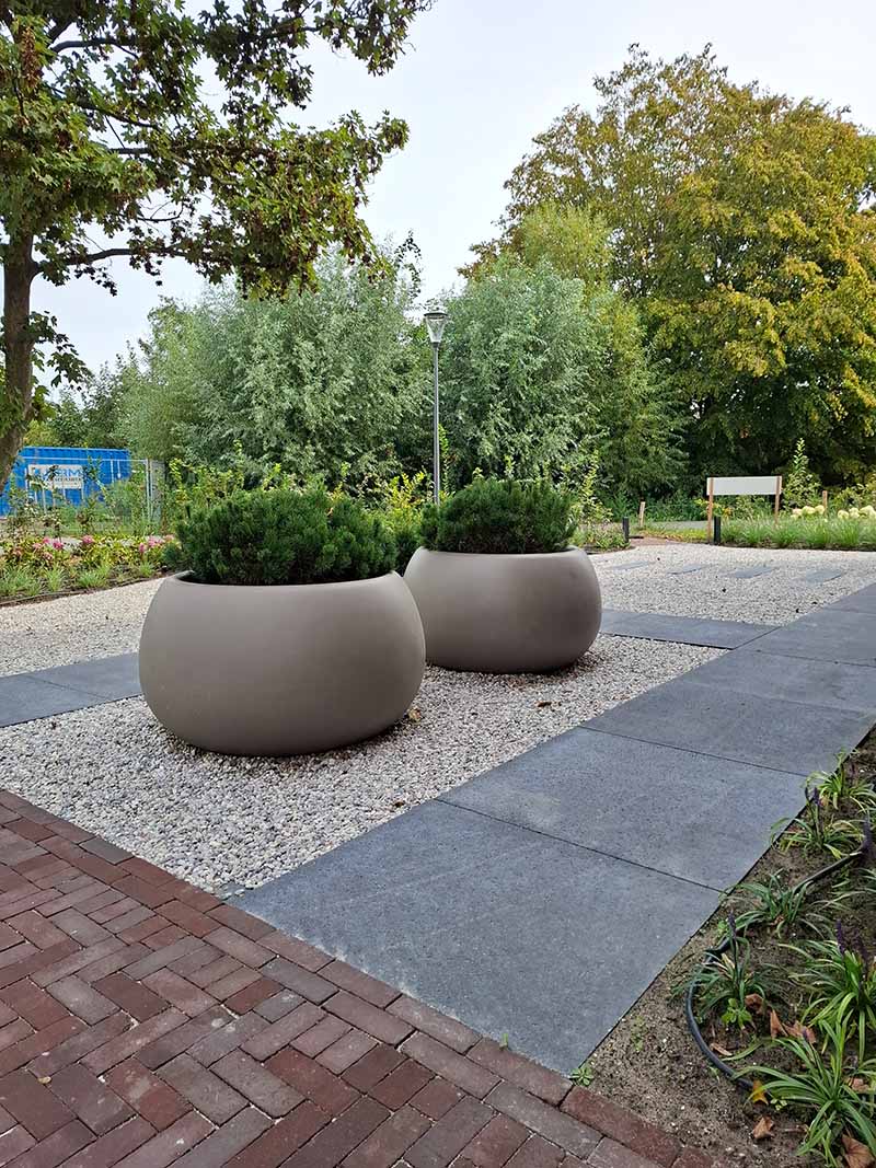 grote-bloempotten-landgoed-coudewater-bersselaargroen Twee grote ovale ADEZZ plantenpotten met Pinus, omringd door Schellevis staptegels en alpengrind in de voortuin op Landgoed Coudewater.